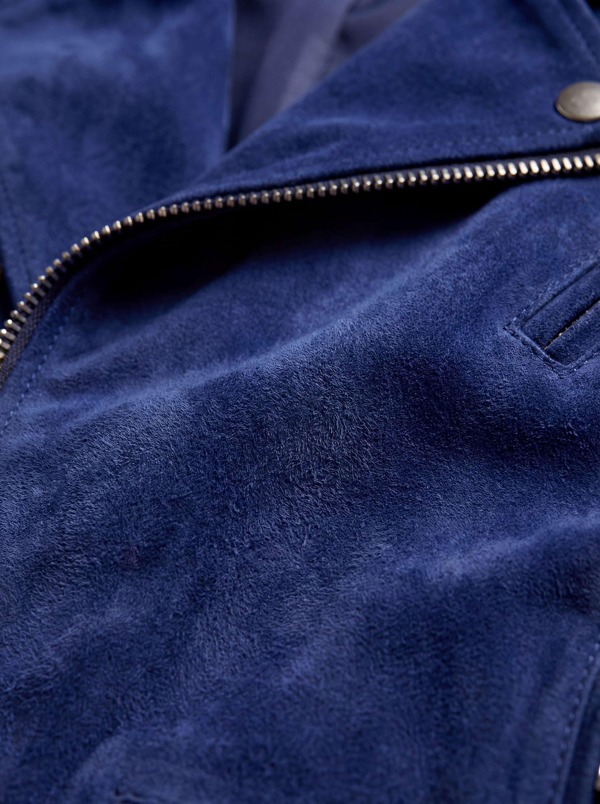Macro shot of soft blue suede texture and silver zipper hardware on biker jacket. The Aether by Maverick Jacket.