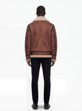 Rear view of male model wearing Maverick Altitude shearling B3 jacket showing structured shoulder fit and shearling-trimmed hem. Maverick Jacket.