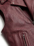 Macro shot of smooth burgundy leather texture and heavy-duty silver zipper hardware on biker vest. The Valor by Maverick Jacket.