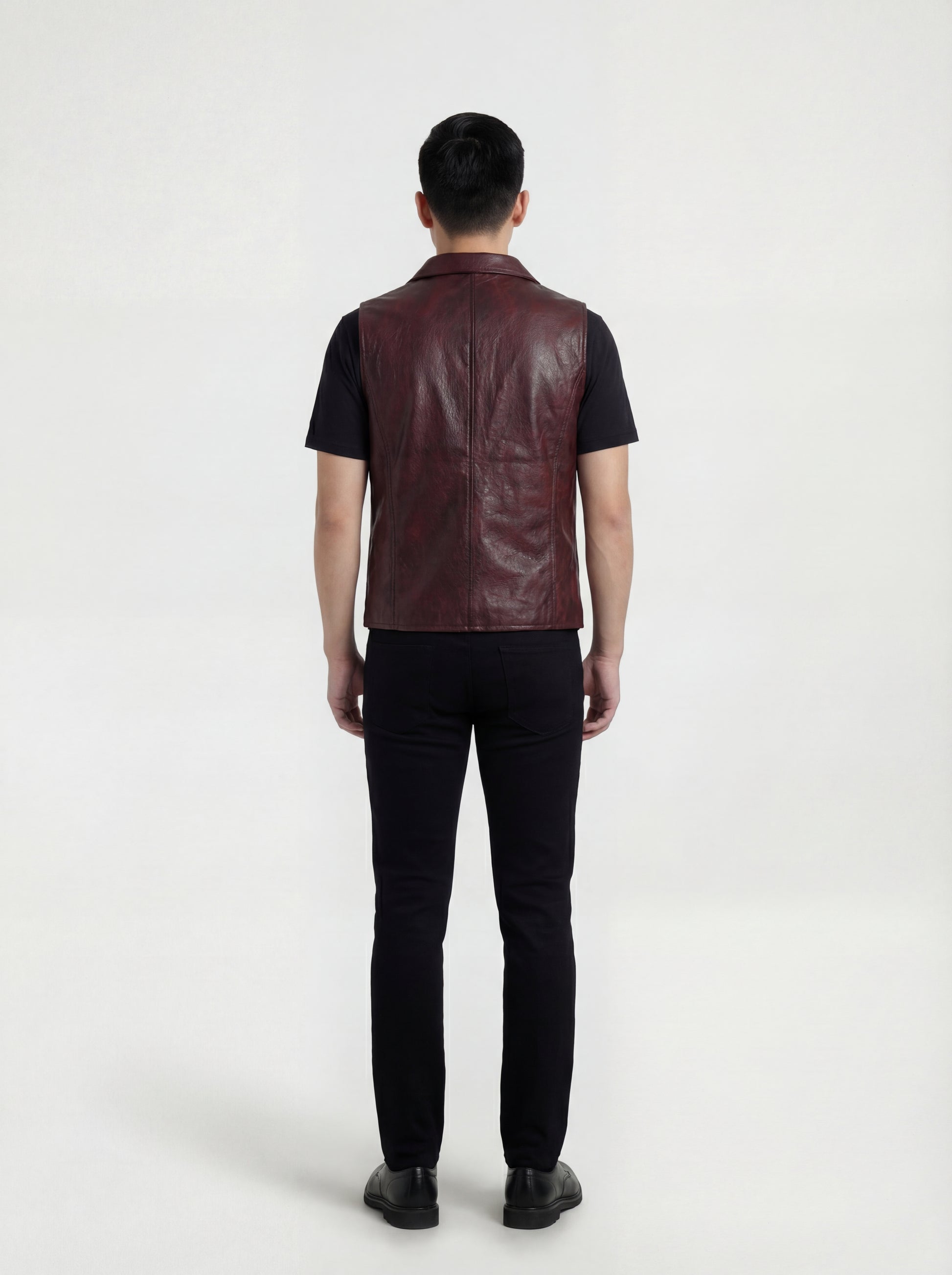 Rear view of male model wearing Maverick Rook leather button vest showing broad shoulder fit and clean back styling. Maverick Jacket.