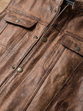 Macro shot of worn distressed leather texture and antique brass hardware on vest. The Drifter by Maverick Jacket.