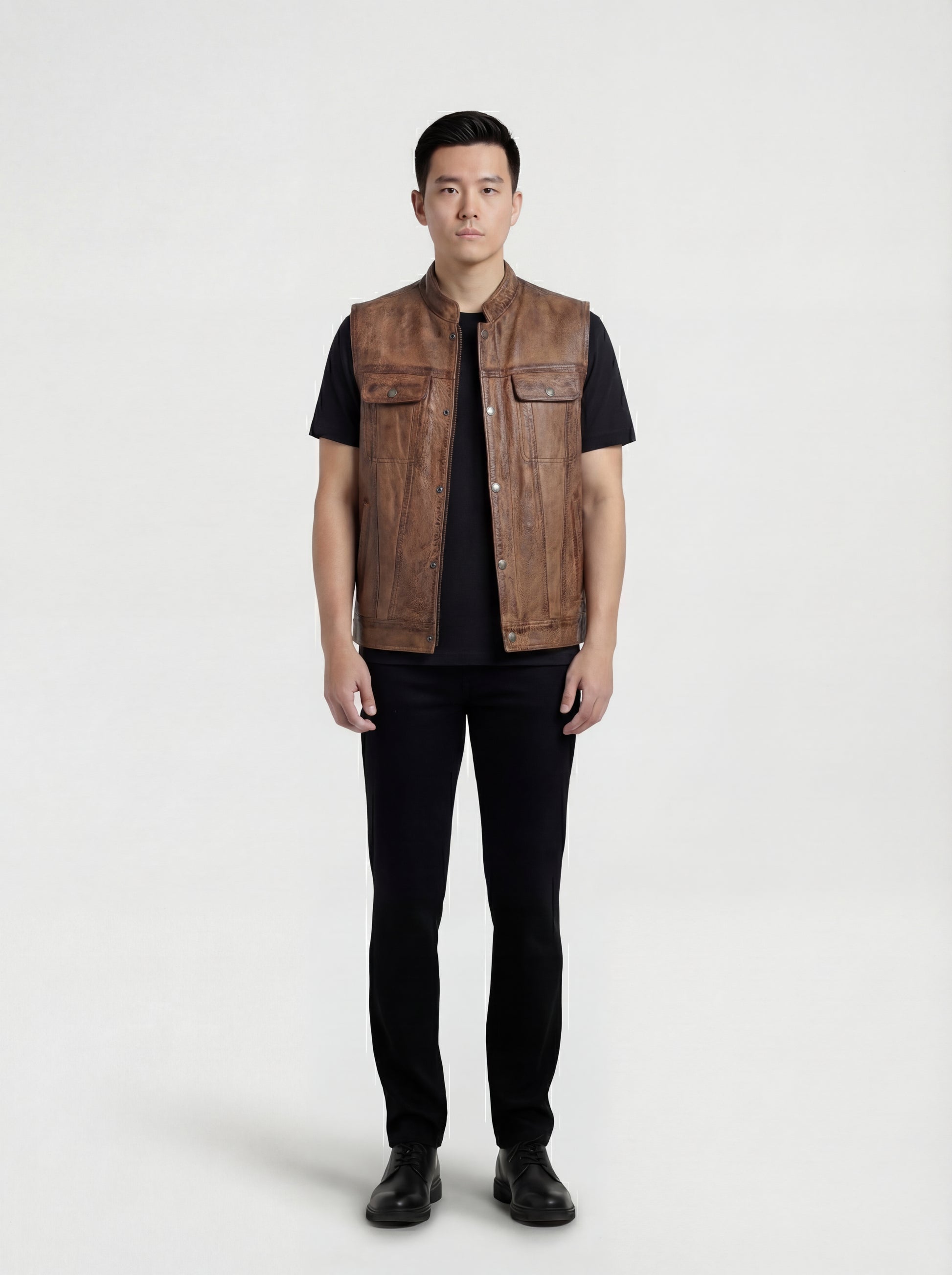 Male model wearing Maverick Drifter distressed leather vest, regular fit, styled over a plaid flannel shirt with dark indigo denim jeans. Maverick Jacket.