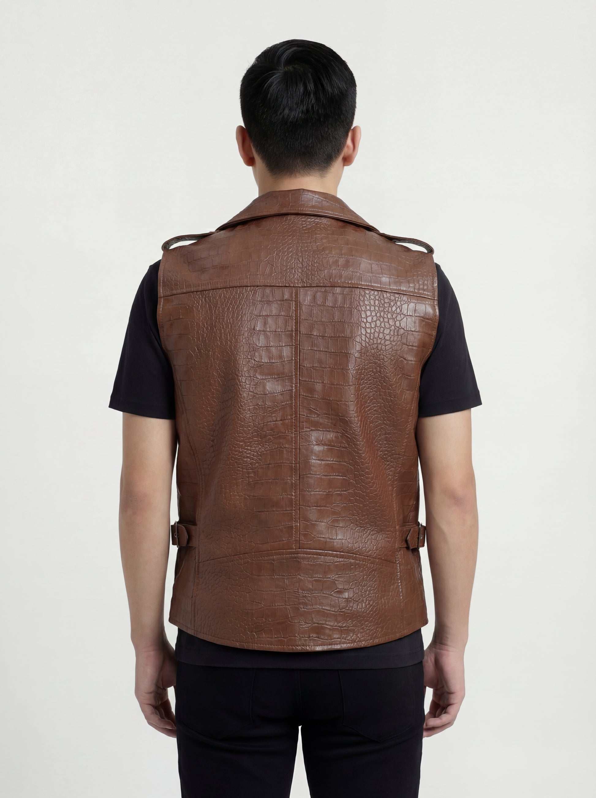 Rear view of male model wearing Maverick Drake croc-embossed leather biker vest showing broad shoulder fit and textured back styling. Maverick Jacket.