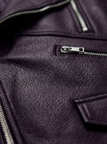 Macro shot of smooth leather texture and heavy-duty metal zipper hardware on biker vest. The Rocco by Maverick Jacket.