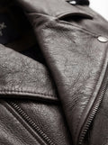 Macro shot of smooth grey leather texture and heavy-duty silver zipper hardware on biker vest. The Vulcan by Maverick Jacket.