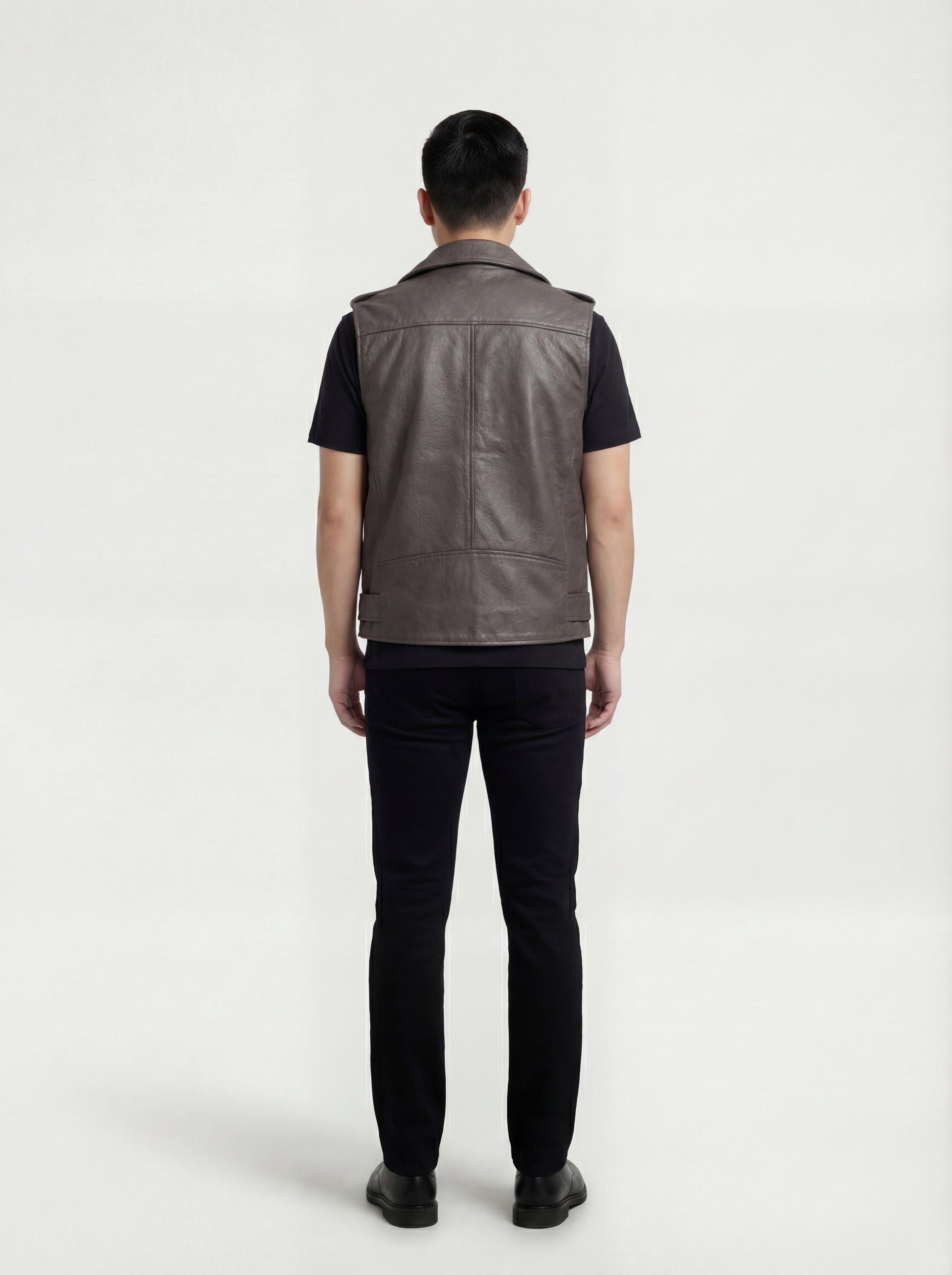 Rear view of male model wearing Maverick Vulcan leather biker vest showing broad shoulder fit and clean back styling. Maverick Jacket.