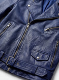 Macro shot of textured blue leather grain and silver asymmetrical zipper hardware on biker jacket. The Vector by Maverick Jacket.