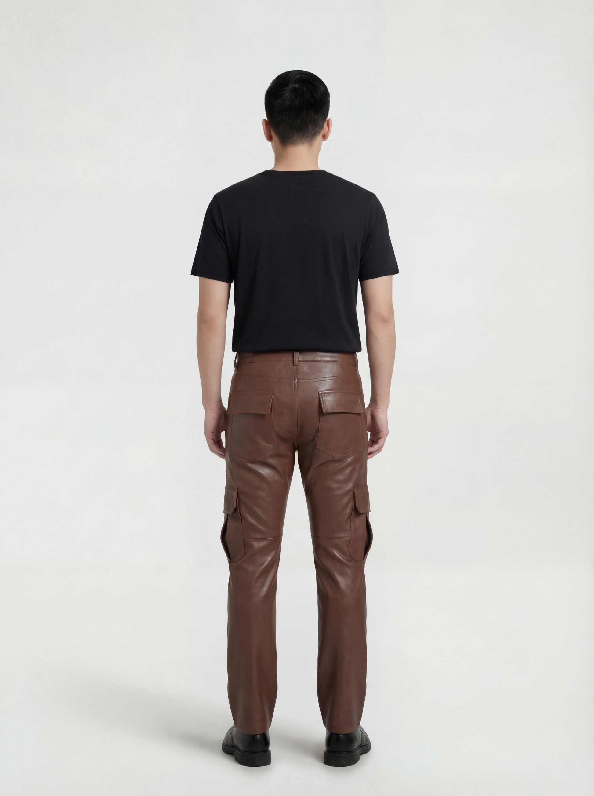 Rear view of male model wearing Maverick Cassian leather cargo trousers showing tailored seat fit and straight leg structure. Maverick Jacket.