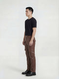 Side profile of Maverick Cassian leather cargo trousers showing dimensional cargo pocket placement and straight silhouette. Maverick Jacket.