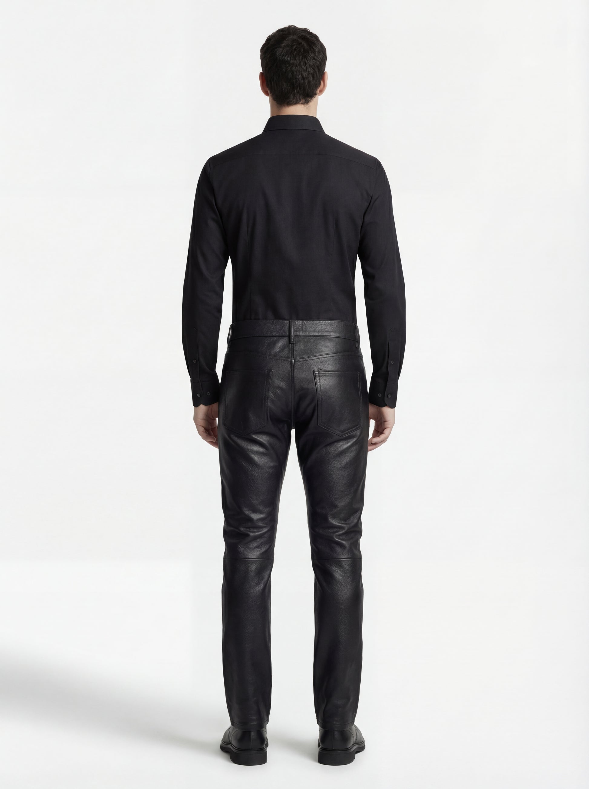 Rear view of male model wearing Maverick Caliber black pebbled leather pant showing fitted seat silhouette and straight leg cut. Maverick Jacket.