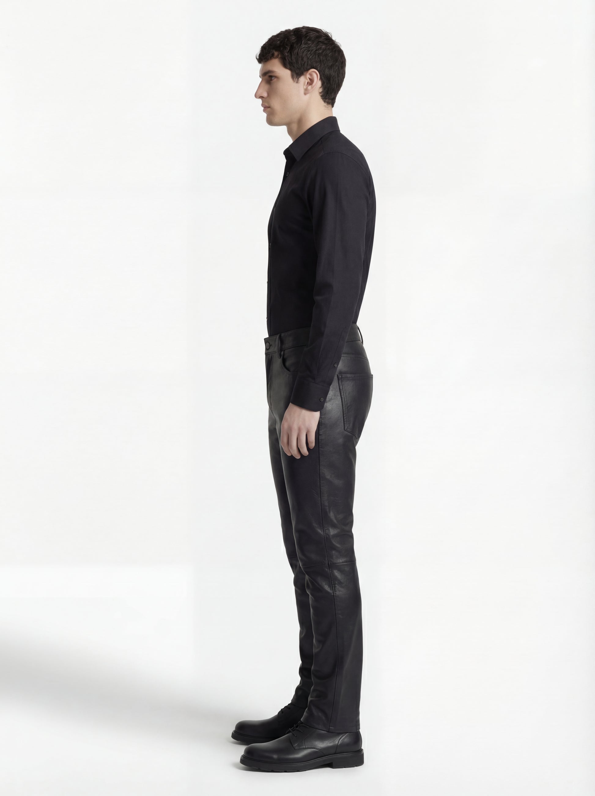 Side profile of Maverick Caliber black leather pant showing knee seam construction and straight leg silhouette. Maverick Jacket.
