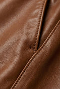 Macro shot of smooth brown leather texture and drawstring waistband detail on jogger pants. Maverick Caelan.