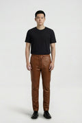 Male model wearing Maverick Caelan brown leather jogger pants, tapered fit, styled with black crew neck t-shirt and black leather boots. Maverick Jacket.