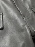 Macro shot of grained grey leather texture and reinforced topstitching on cargo pants. The Cassian by Maverick Jacket.
