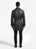 Rear view of male model wearing Maverick Sovereign leather trench coat showing structured shoulder fit and clean vertical back paneling. Maverick Jacket.