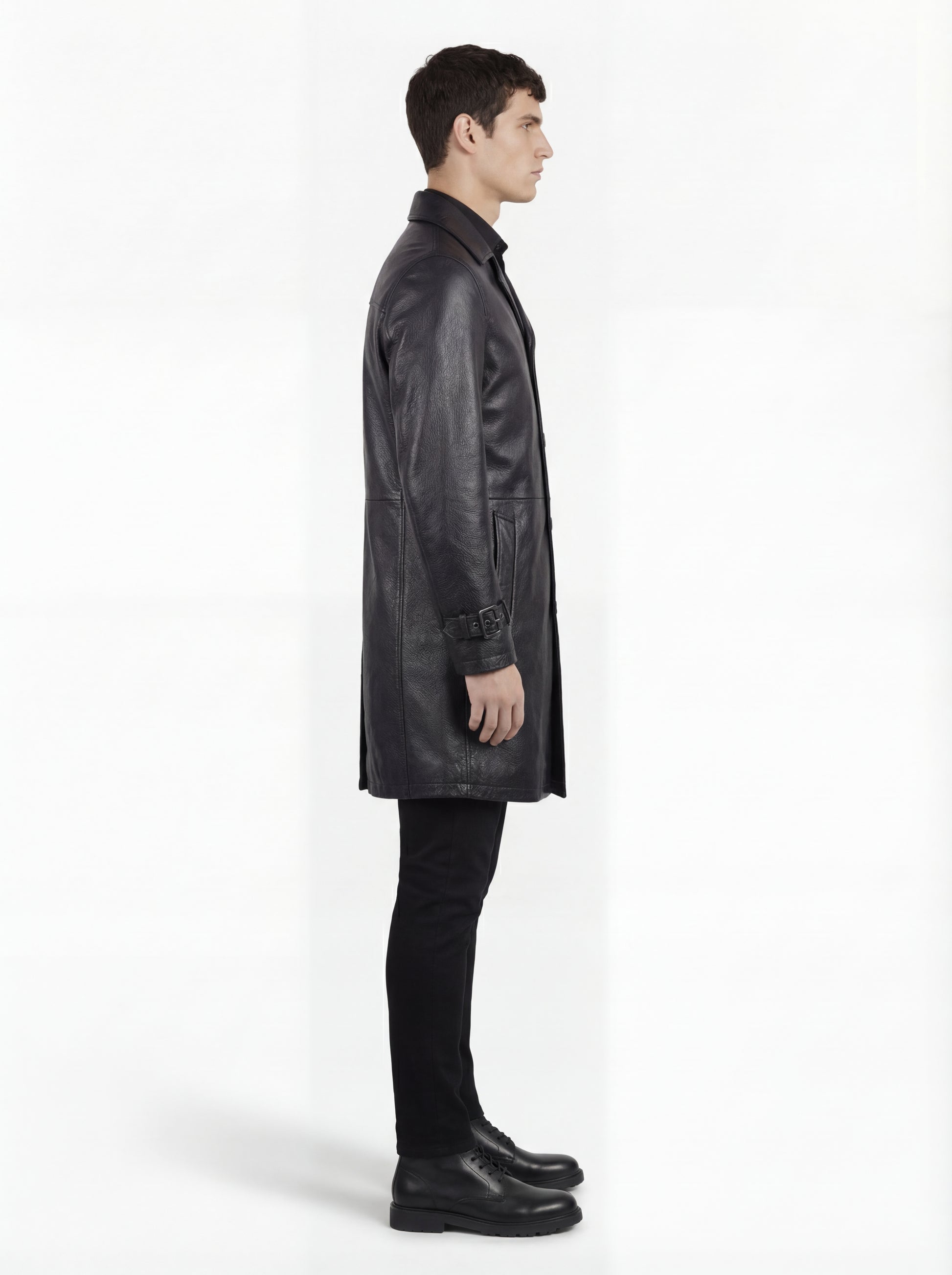 Side profile of Maverick Hawk leather car coat showing long sleeve structure with cuff strap and straight mid-length silhouette. Maverick Jacket.