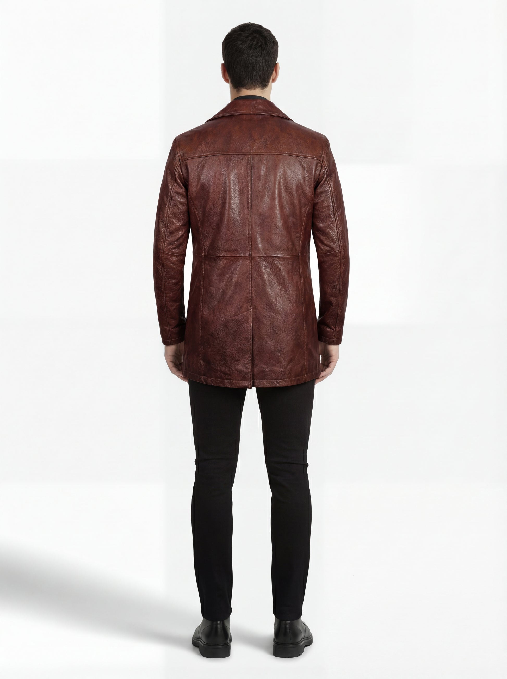 Rear view of male model wearing Maverick Consul leather coat showing structured shoulder fit and clean back paneling. Maverick Jacket.