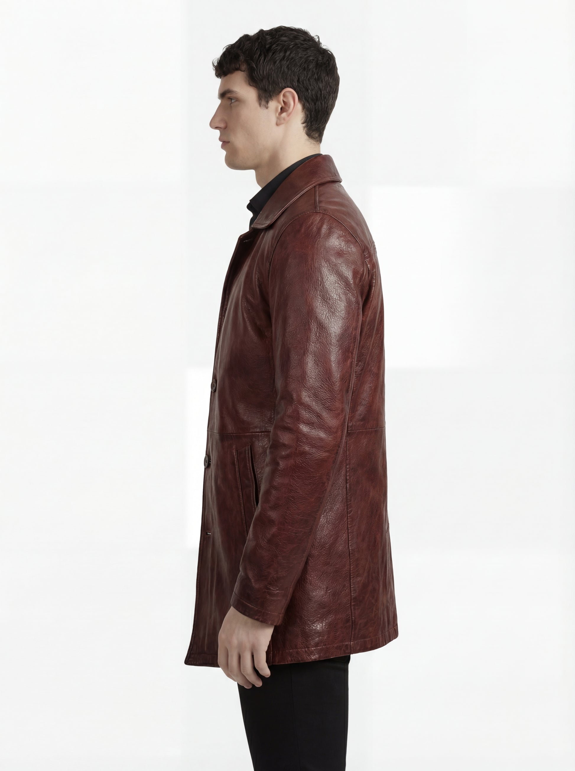 Side profile of Maverick Consul leather coat showing long sleeve structure and straight mid-length silhouette. Maverick Jacket.