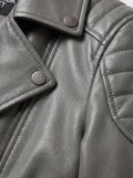 Macro shot of grained grey leather texture and silver snap button lapel detail on biker jacket. The Morrigan by Maverick Jacket.