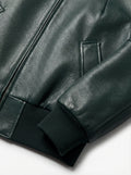 Macro shot of grained green leather texture and ribbed knit cuff detail on bomber jacket. The Isla by Maverick Jacket.