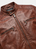 Macro shot of textured brown leather grain and gunmetal zipper hardware on cafe racer jacket. The Meridian by Maverick Jacket. 