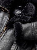 Macro shot of pebbled black leather grain and soft black shearling texture on collar. The Kira by Maverick Jacket.