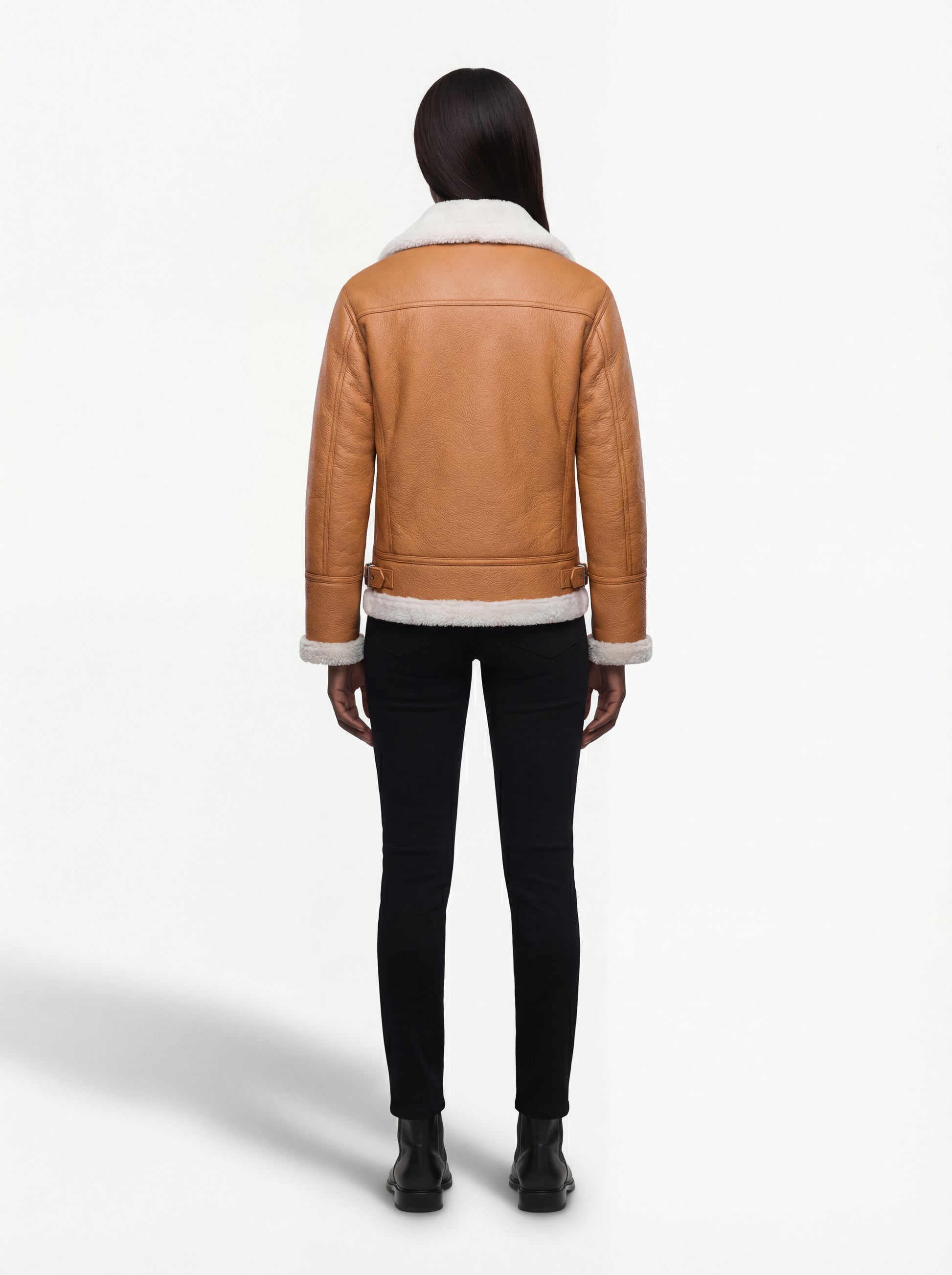 Rear view of female model wearing Maverick Flare aviator jacket showing fitted shoulder structure and clean back paneling. Maverick Jacket.