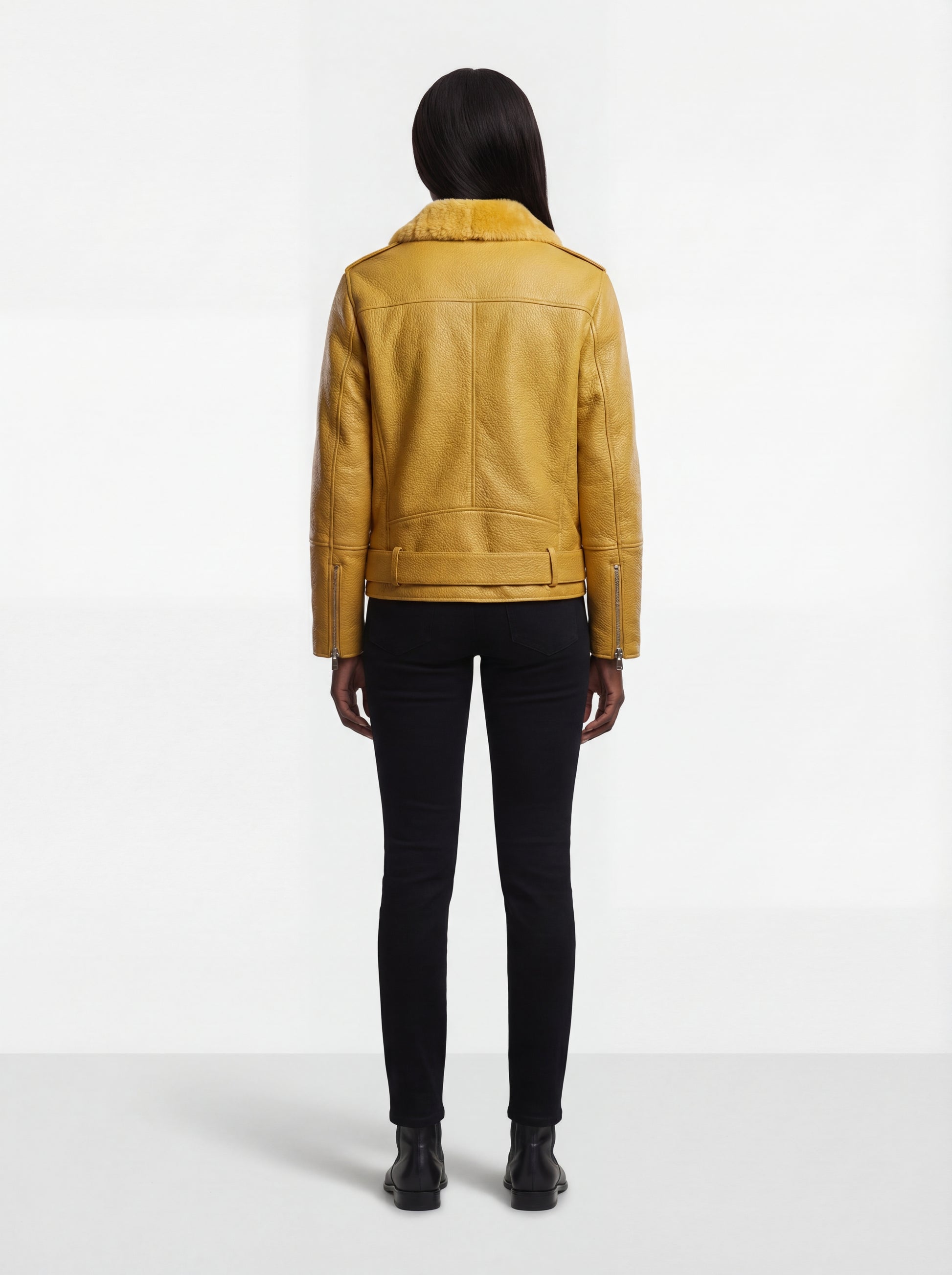 Rear view of female model wearing Maverick Solar biker jacket showing fitted shoulder structure and belted hem styling. Maverick Jacket.