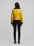 Rear view of female model wearing Maverick Voltage shearling jacket showing structured shoulder fit and clean back paneling. Maverick Jacket.