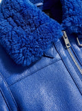 Macro shot of electric blue pebbled leather grain and soft blue shearling texture on collar. The Cobalt by Maverick Jacket.