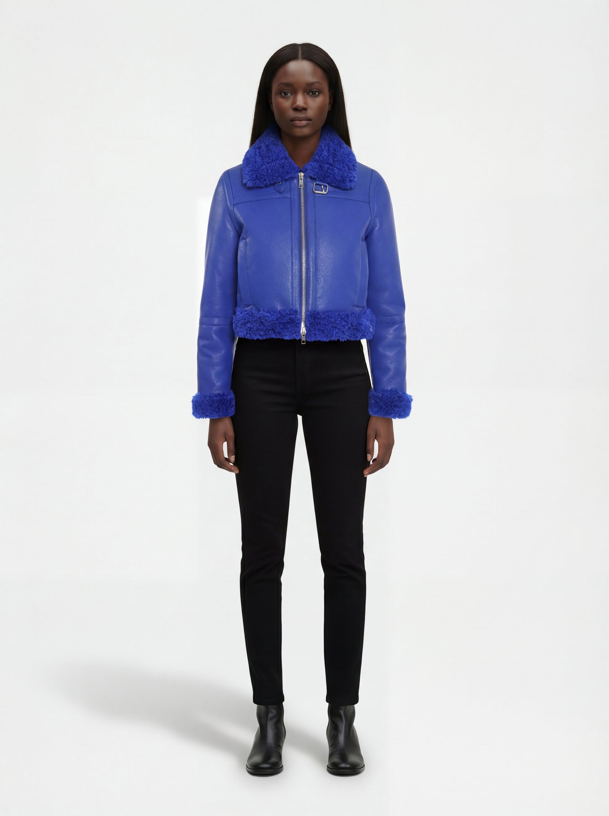 Female model wearing Maverick Cobalt shearling biker jacket, cropped fit, styled with black skinny jeans and leather ankle boots. Maverick Jacket.