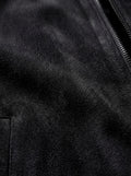Macro shot of soft black suede texture and metal zipper hardware on bomber jacket. The Felix by Maverick Jacket.