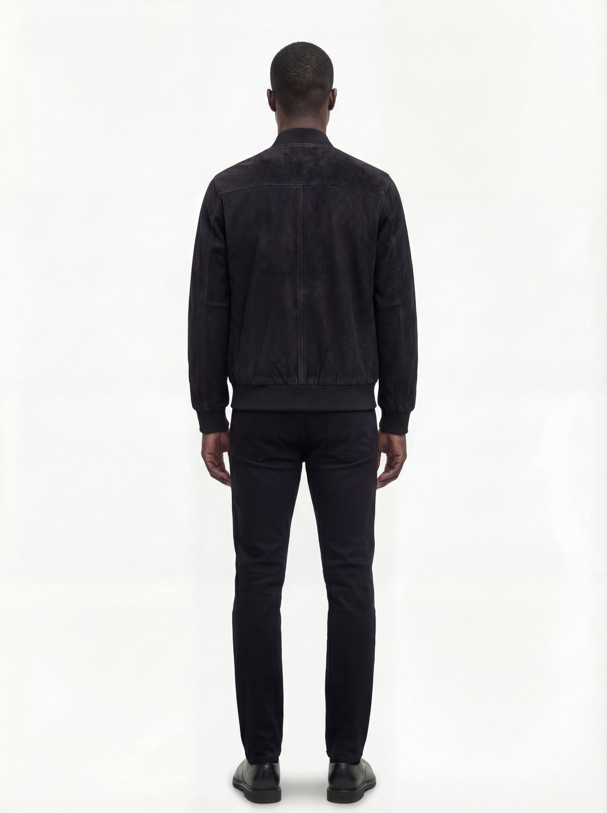 Rear view of male model wearing Maverick Felix suede bomber jacket showing broad shoulder fit and ribbed waist styling. Maverick Jacket.