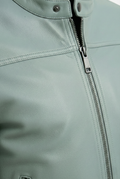 Macro shot of sage green pebbled leather grain and gunmetal zipper hardware on biker jacket. The Orion by Maverick Jacket.