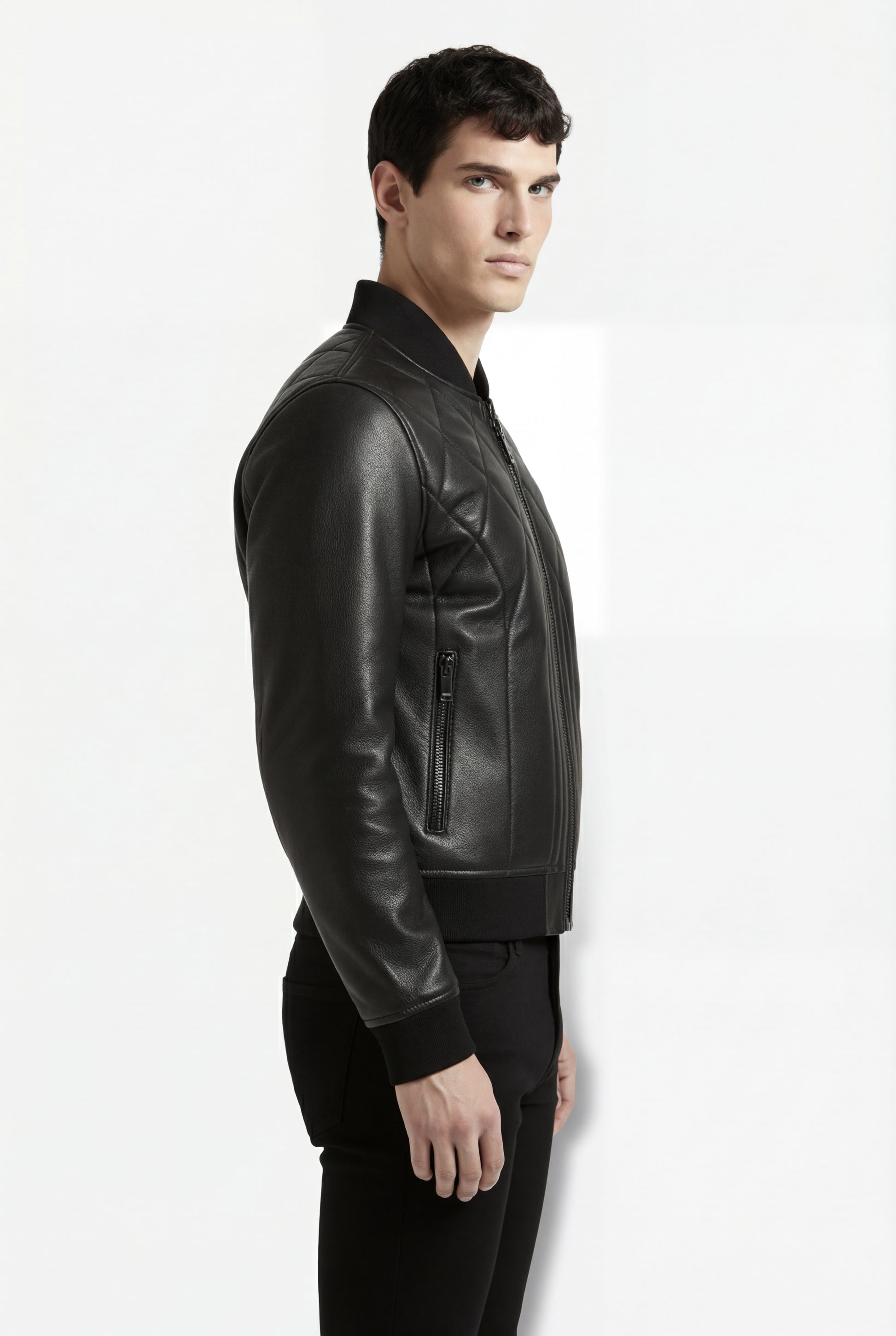 Rear view of male model wearing Maverick Vanta bomber jacket showing structural quilted back yoke and fitted ribbed waistband. Maverick Jacket.