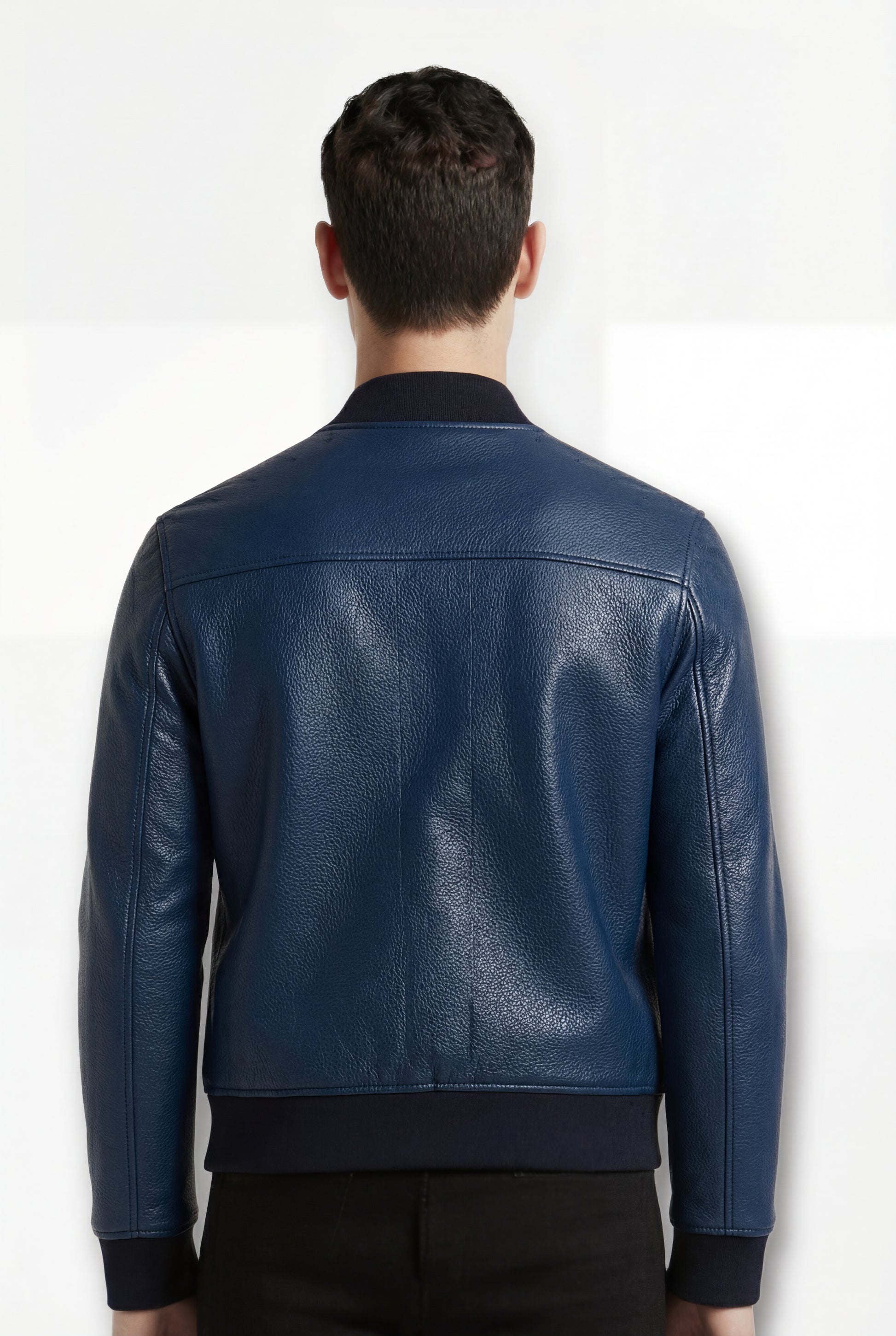 Rear view of male model wearing Maverick Solaro leather bomber jacket showing structured shoulder fit and ribbed hem styling. Maverick Jacket.