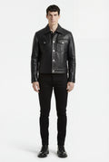 Male model wearing Maverick Veyron leather trucker jacket, slim fit, styled with black slim-fit trousers and black boots. Maverick Jacket.