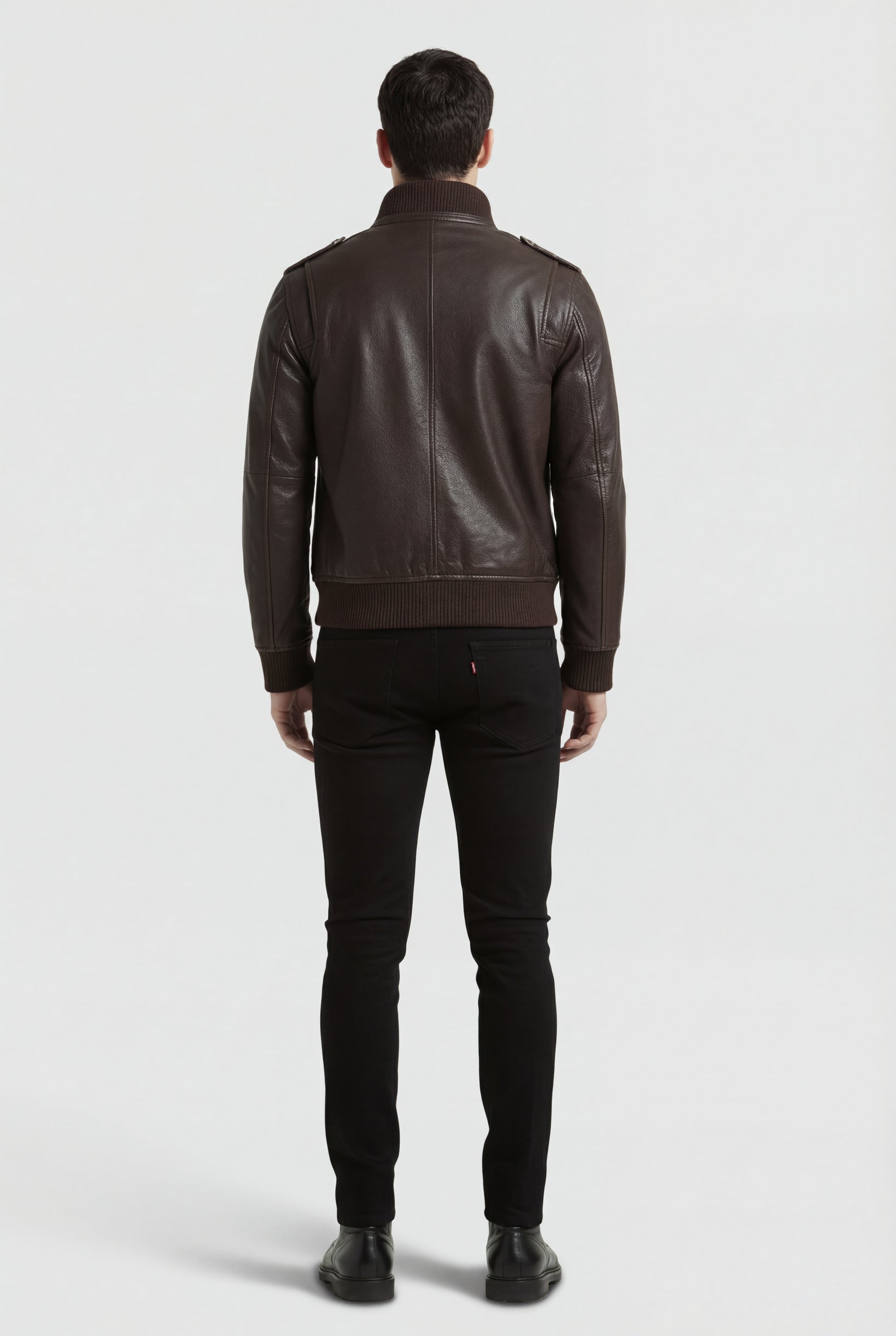 Rear view of male model wearing Maverick Alder leather bomber jacket showing broad shoulder fit and ribbed hem styling. Maverick Jacket.