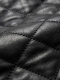 Macro shot of black leather texture and intricate diamond stitching detail on bomber jacket. The Nero by Maverick Jacket.