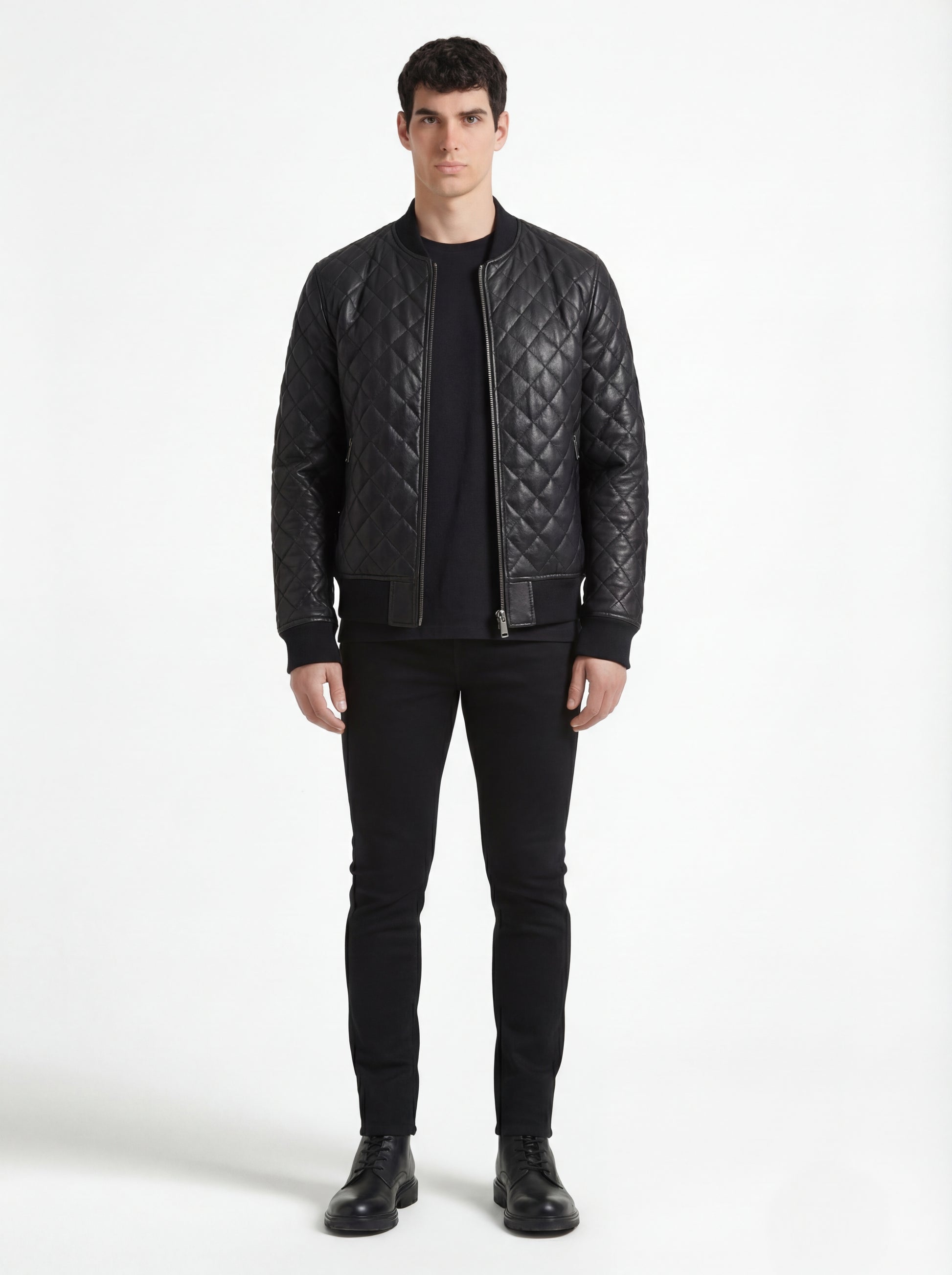 Male model wearing Maverick Nero quilted bomber jacket, slim fit, styled with black t-shirt and black skinny jeans. Maverick Jacket.