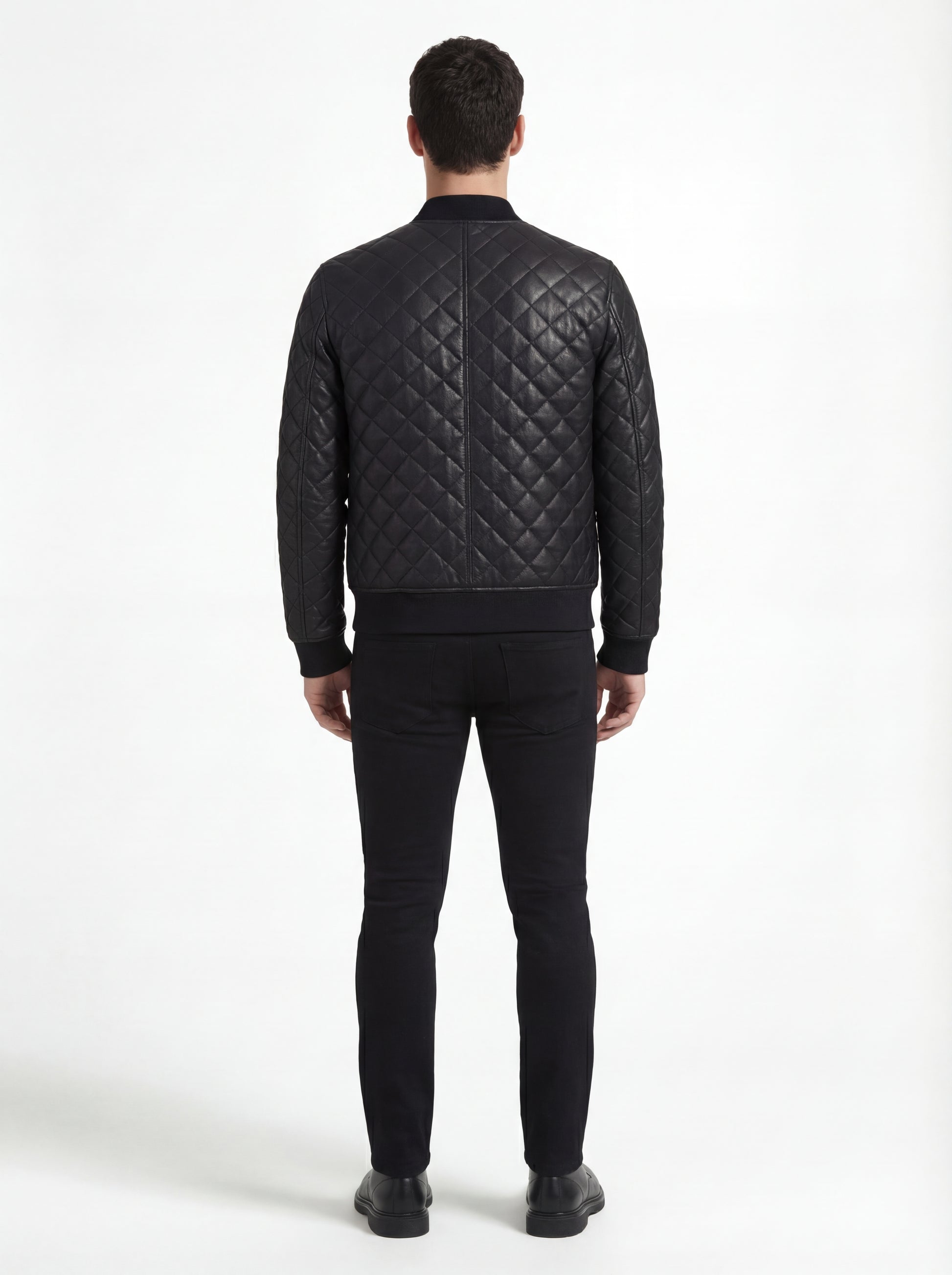 Rear view of male model wearing Maverick Nero quilted bomber jacket showing structured shoulder fit and diamond back paneling. Maverick Jacket.