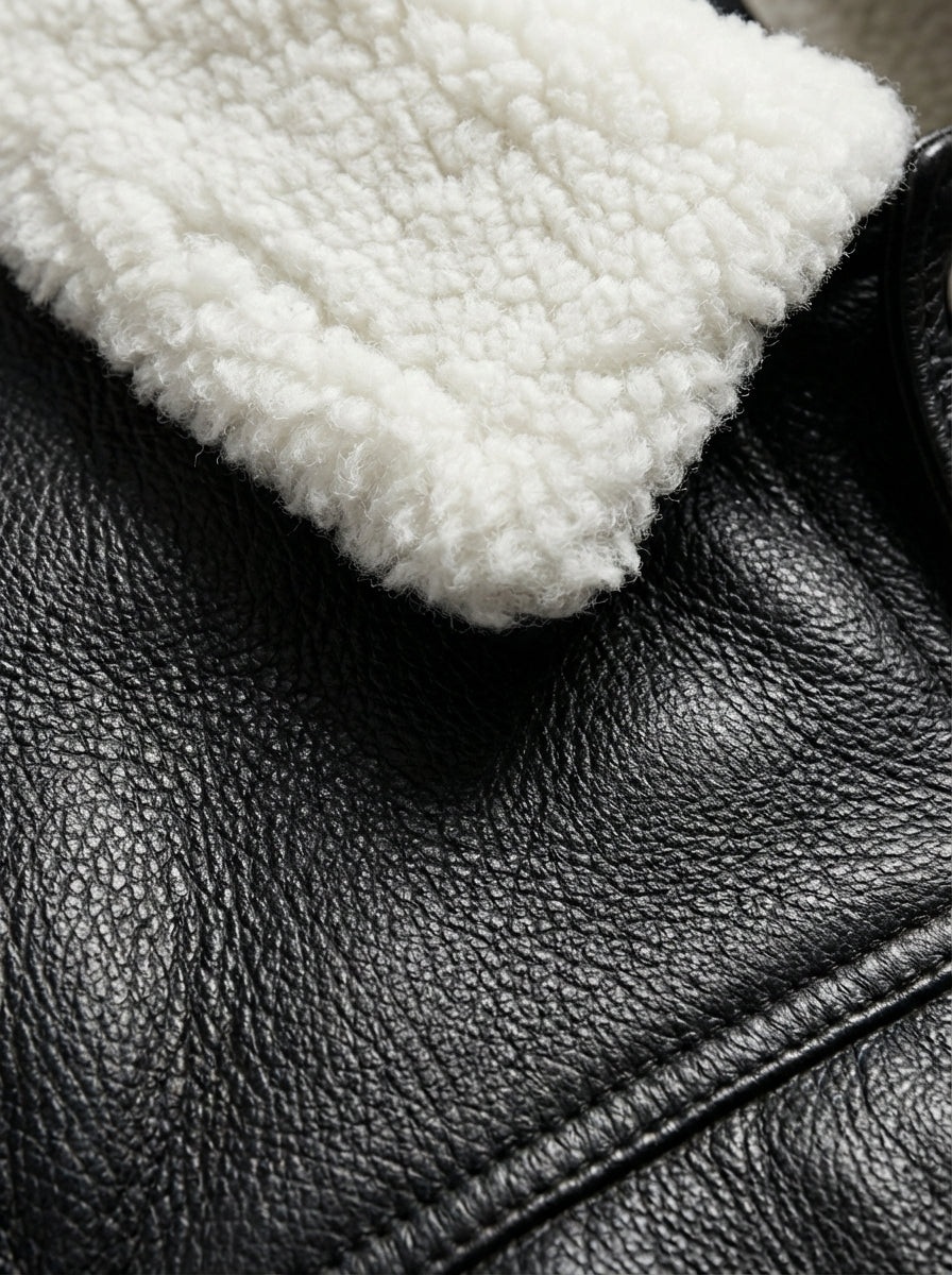 Macro shot of pebbled black leather texture and white shearling collar fleece on jacket. The Corbin by Maverick Jacket.