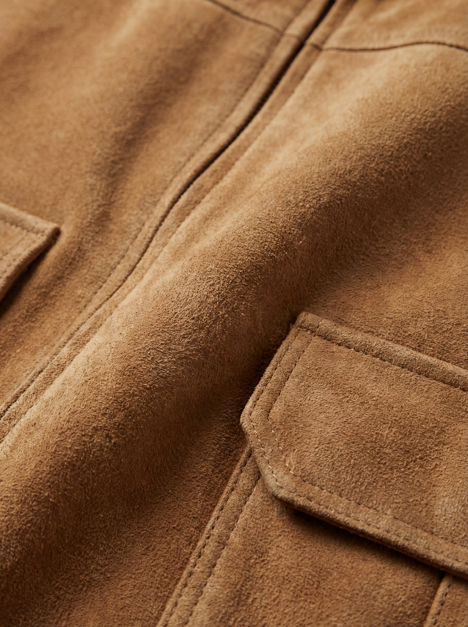 Macro shot of brushed tan suede texture and reinforced pocket stitching on jacket. The Caden by Maverick Jacket.
