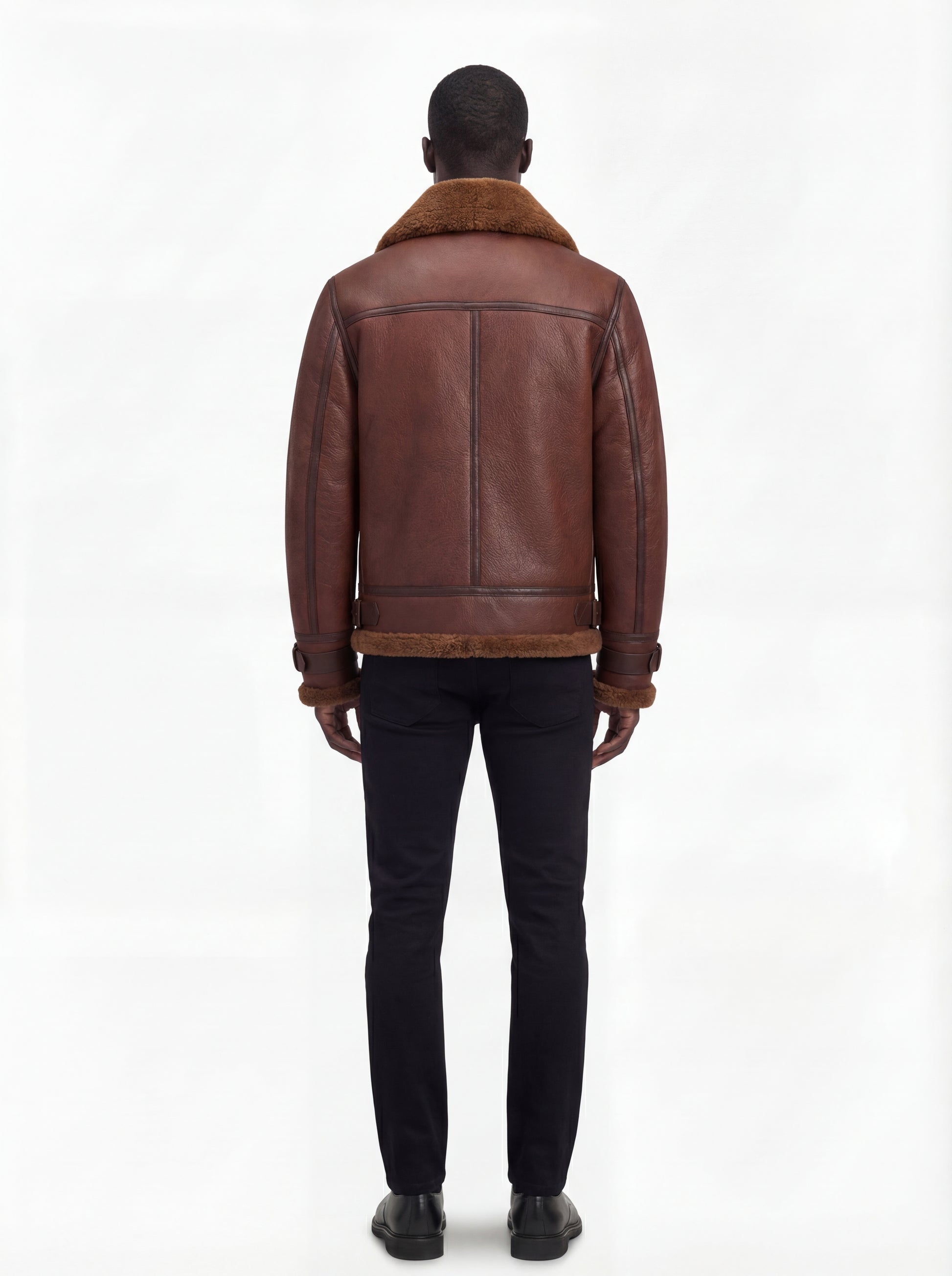 Rear view of male model wearing Maverick Sol B3 shearling bomber jacket showing broad shoulder fit and shearling-trimmed hem. Maverick Jacket.