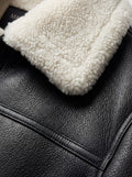 Macro shot of pebbled black leather texture and thick white shearling collar on bomber jacket. The Ronan by Maverick Jacket.