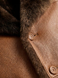 Macro shot of pebbled leather texture and button closure with dark shearling trim on coat. The Alistair by Maverick Jacket.