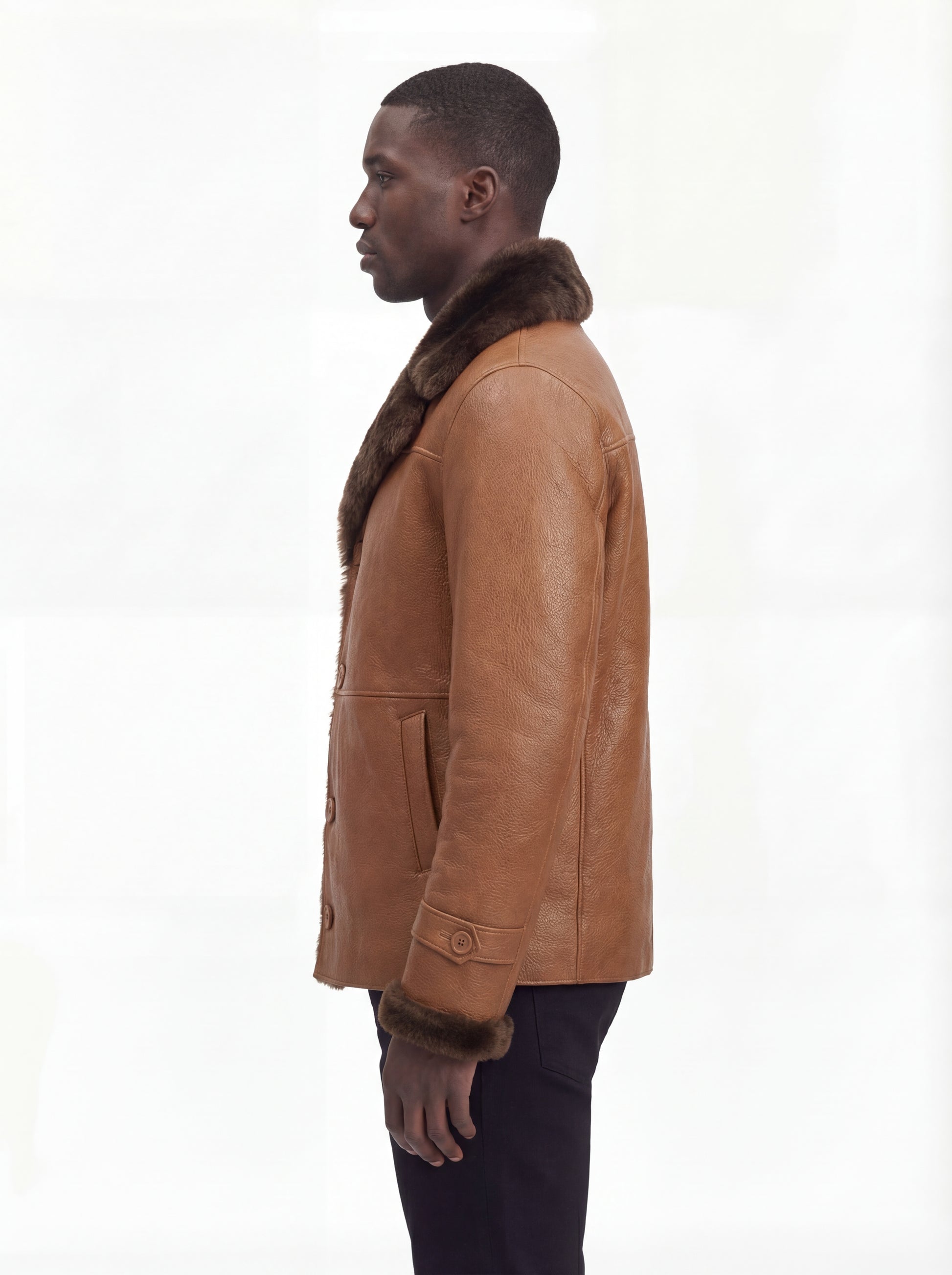 Side profile of Maverick Alistair showing shearling cuff detail and straight mid-length silhouette. Maverick Jacket.