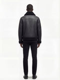 Rear view of male model wearing Maverick Zane shearling jacket showing structured shoulder fit and shearling-trimmed hem. Maverick Jacket.