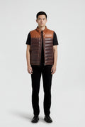 Male model wearing Maverick Caleb two-tone leather puffer vest, regular fit, styled over a grey hoodie with black denim jeans. Maverick Jacket.
