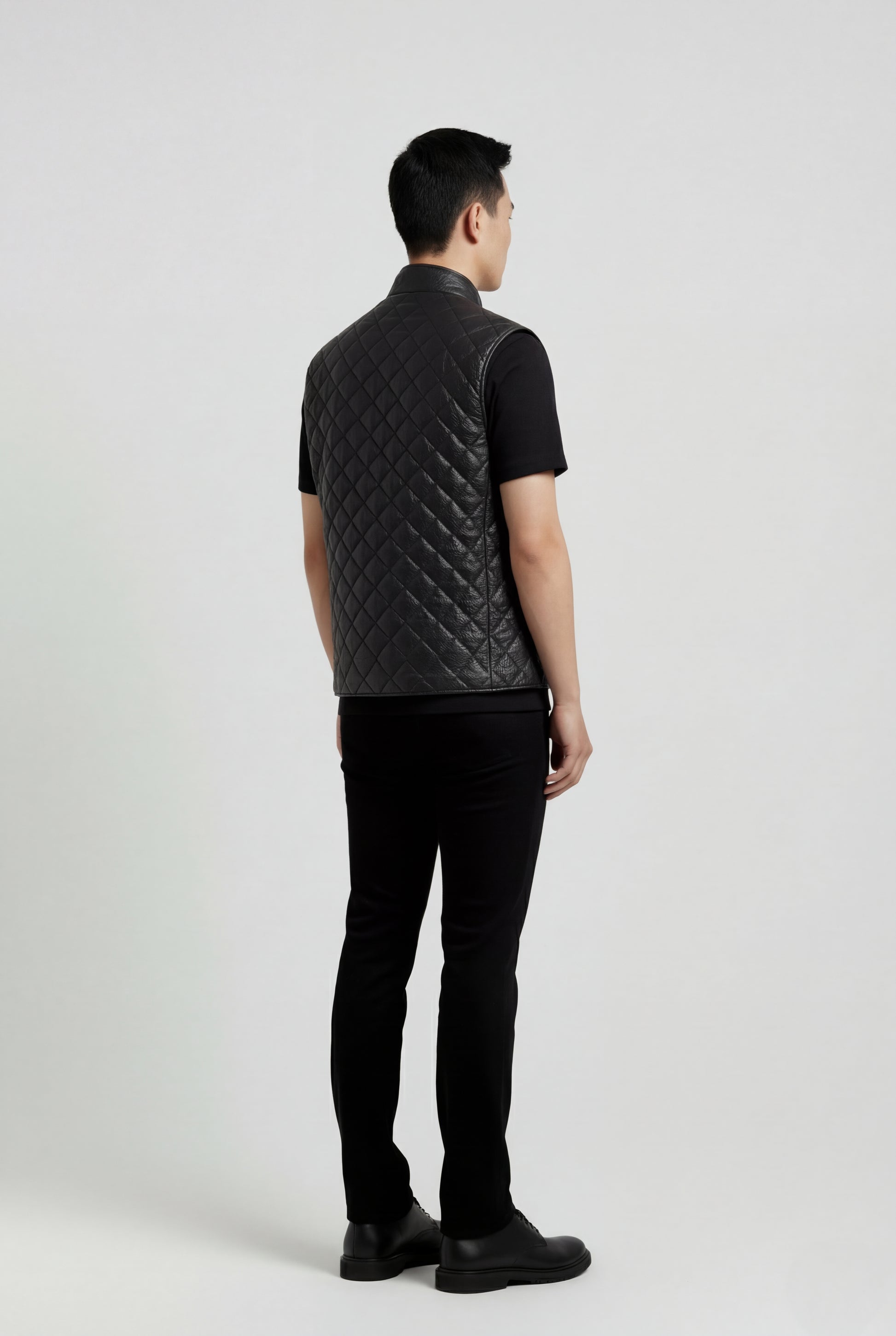 Rear view of male model wearing Maverick Graham quilted leather vest showing broad shoulder fit and diamond quilted back styling. Maverick Jacket.